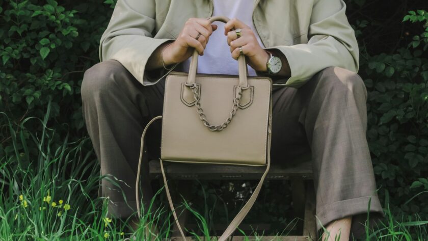 a person sitting on a bench holding a purse