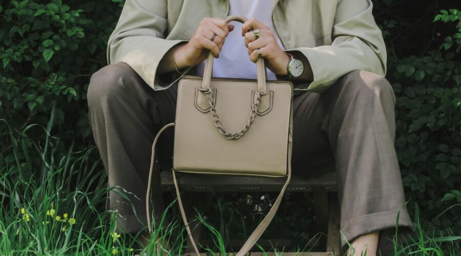 a person sitting on a bench holding a purse