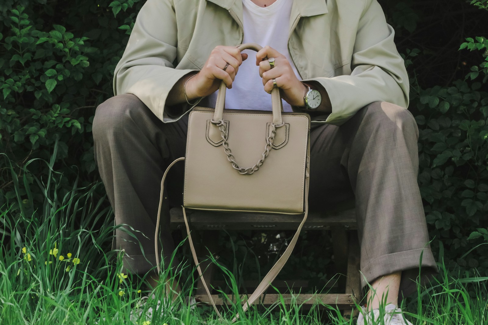 a person sitting on a bench holding a purse