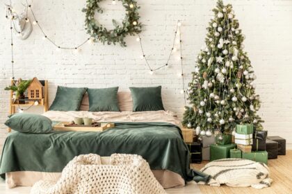 Stylish bedroom decorated with Christmas lights and a tree, creating a warm festive ambiance.