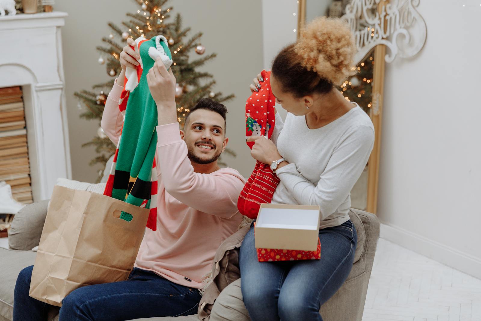 A joyful couple exchanging Christmas presents in a cozy living room.